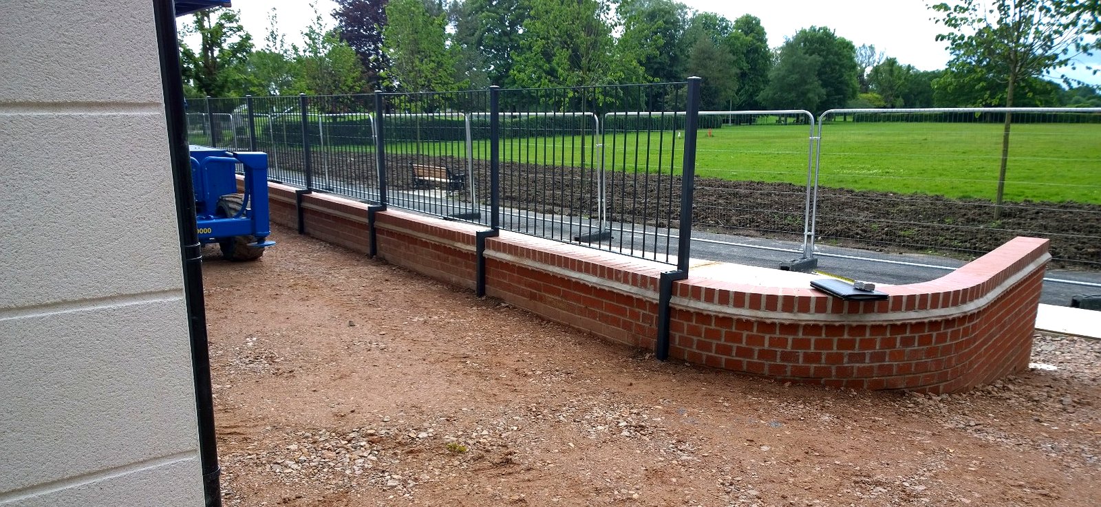 External metal wall railings around the Radlett development on a curved brick wall